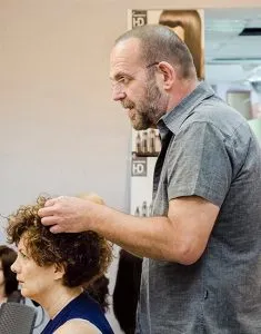 גבר מעצב שיער מתולתל של אישה